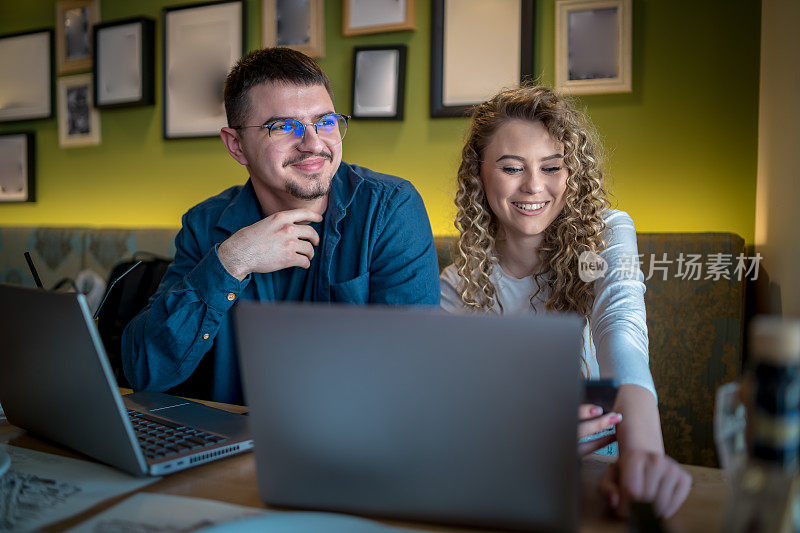 Business people working together at a café using their laptops